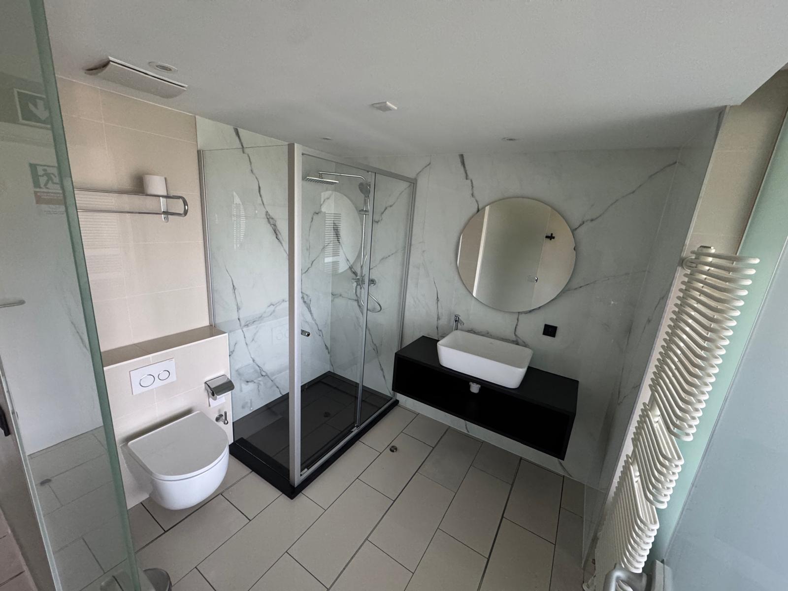 Neu gestalteter Badbereich mit Dusche und Waschtisch beim Projekt NUMA Bonn